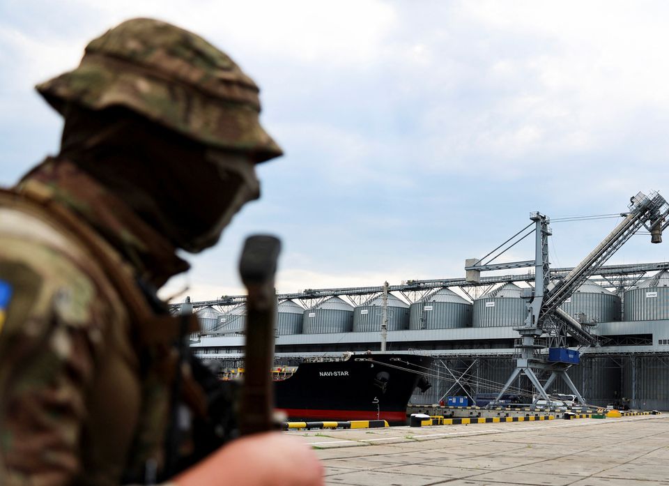 A Ukrainian serviceman stands in front of silos of grain from Odesa Black Sea port, before the shipment of grain as the government of Ukraine awaits signal from UN and Turkey to start grain shipments, amid Russia's invasion of Ukraine, in Odesa, Ukraine July 29, 2022. REUTERS/Nacho Doce
