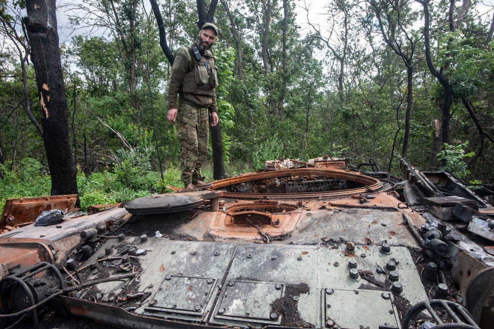 A Ukrainian serviceman stands atop a destroyed tank, in this handout picture released August 1, 2022. (Reuters)