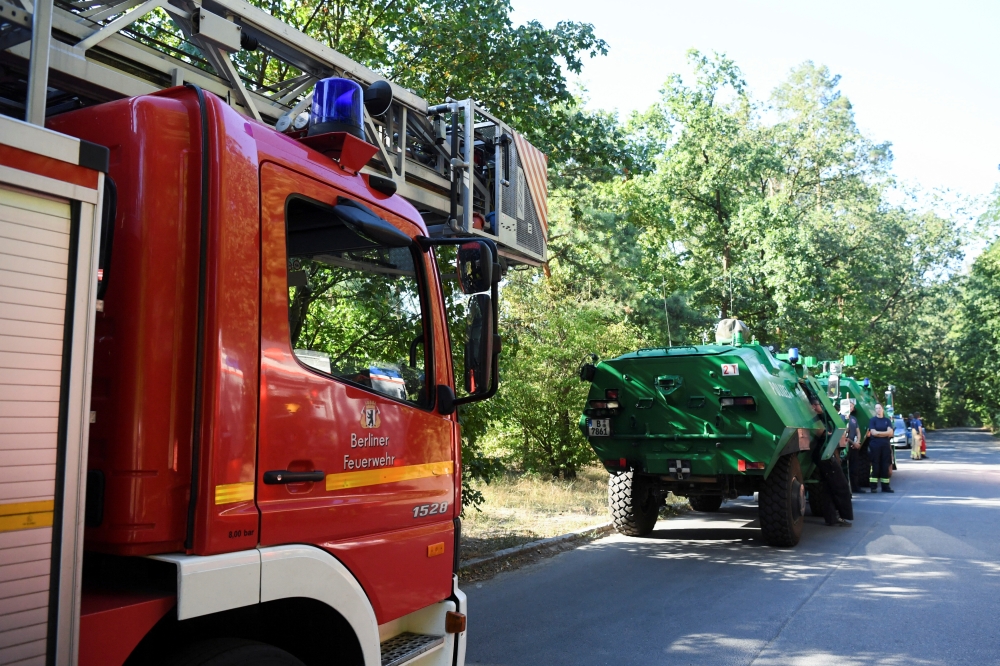 Firefighter vehicles are seen near the closed motorway access Huettenweg, due to an explosion in munitions depot in the Grunewald forest in Berlin, Germany August 4, 2022. REUTERS/Annegret Hilse
