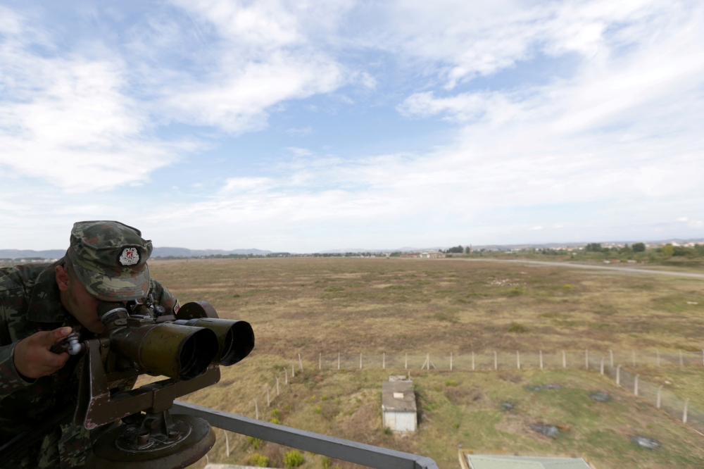 File Photo: An Albanian Military Force member uses binoculars in Kucova Air Base in Kucova, Albania, on October 3, 2018. (REUTERS/Florion Goga)