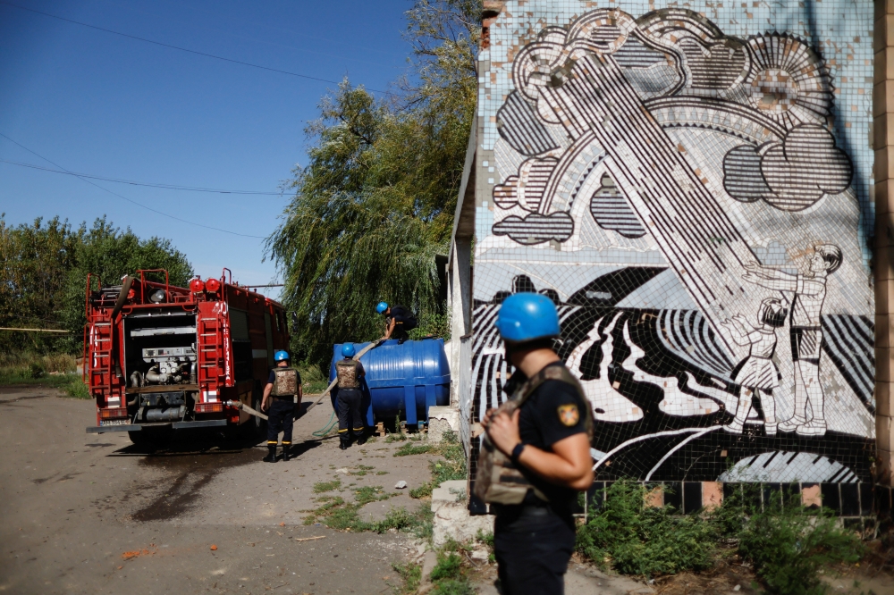 Emergency Service workers fill up a water deposit, as Russia's attack on Ukraine continues, in Toretsk, Donetsk region, Ukraine on Monday. REUTERS/Ammar Awad