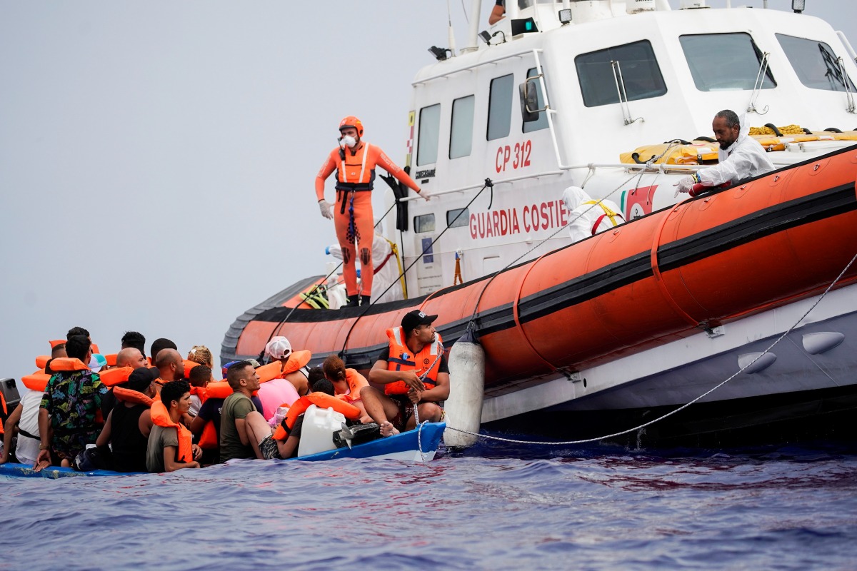 Members of Italian Guardia Costiera prepare to bring on board the migrants of a wooden boat near the island of Lampedusa, in the Mediterranean Sea, on September 1, 2021. File Photo / REUTERS/Juan Medina