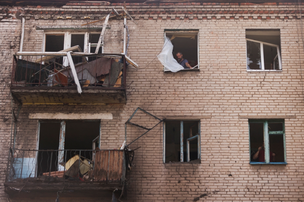 A Ukrainian man checks damage in houses following recent Russian shelling, as Russia's attack in Ukraine continues, in the city of Slovyansk, in Donetsk region, Ukraine August 28,2022. REUTERS/Ammar Awad