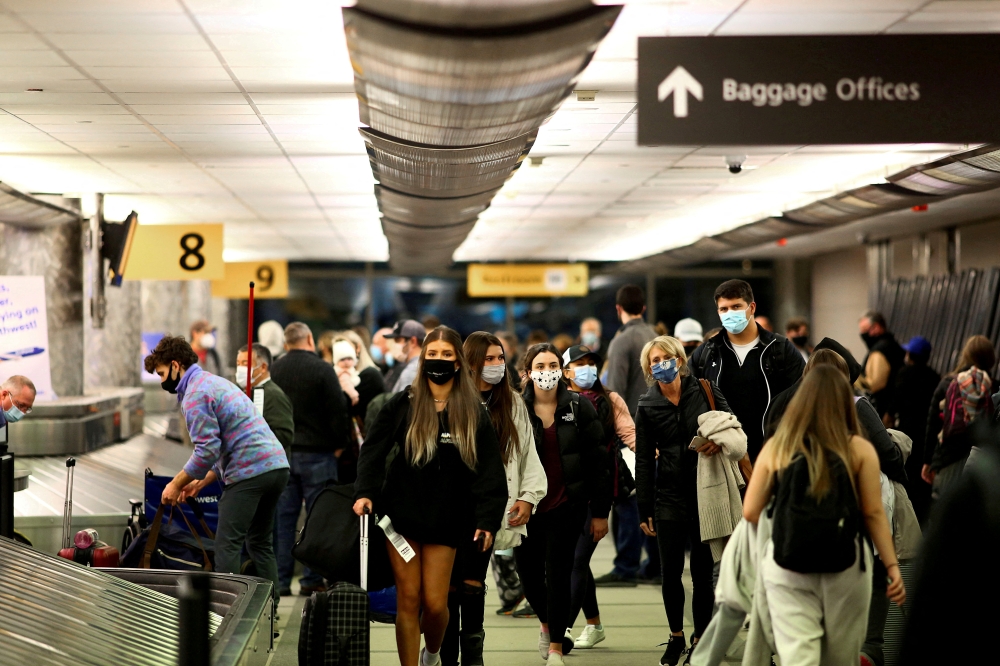 File Photo: Travelers wearing protective face masks to prevent the spread of the coronavirus disease reclaim their luggage at the airport in Denver, Colorado, US, November 24, 2020. (REUTERS/Kevin Mohatt)