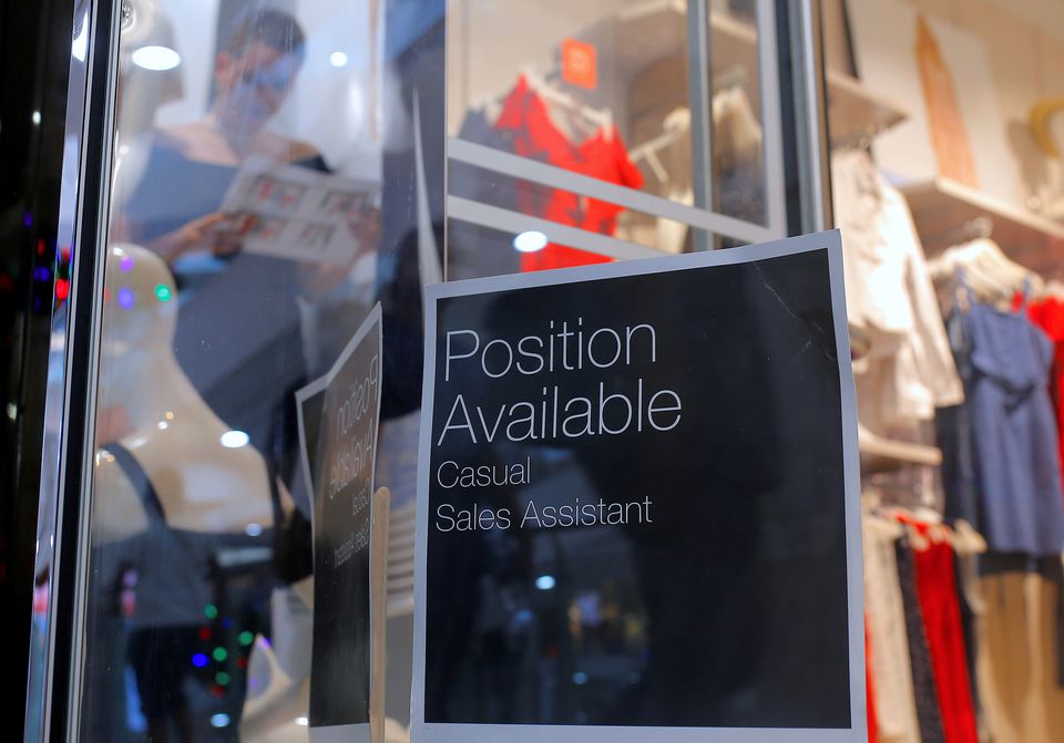 A sales assistant is seen through the window of a retail store displaying a job vacancy sign in central Sydney, Australia, December 5, 2016. Picture taken December 5, 2016. REUTERS/Steven Saphore

