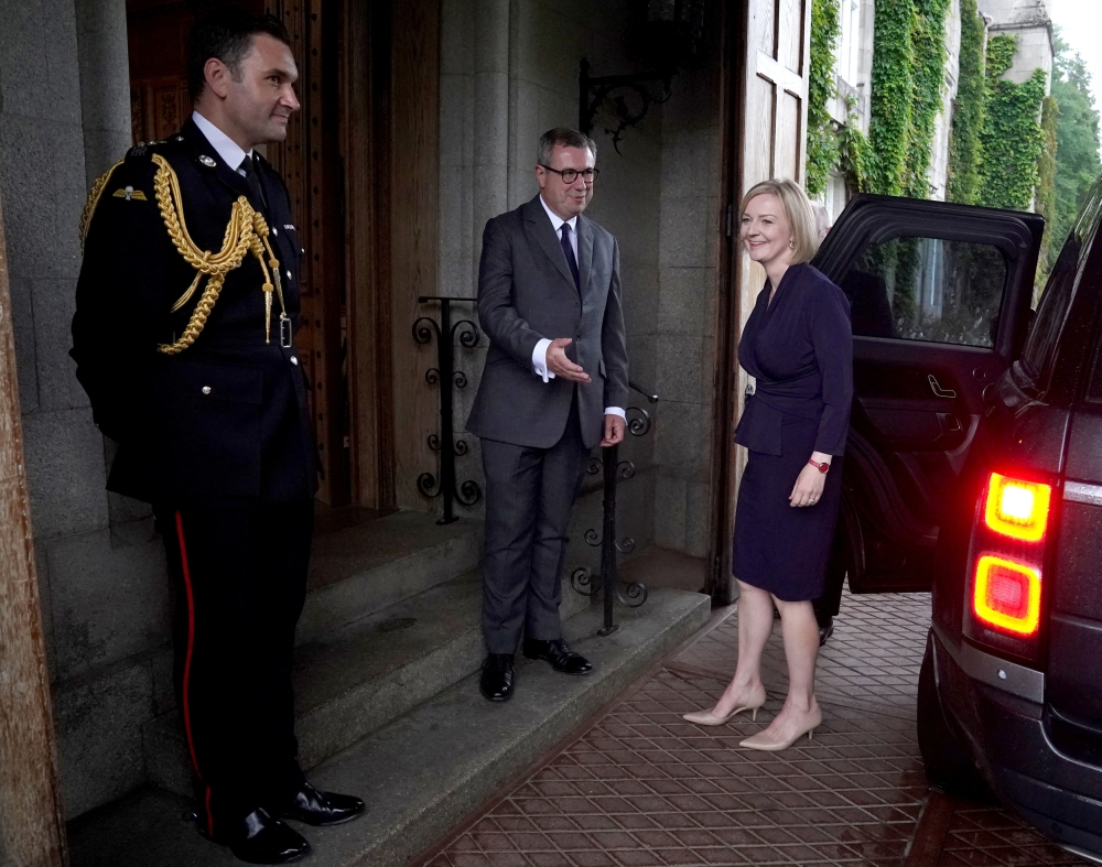 Newly elected leader of the Conservative party Liz Truss is greeted by Britain's Queen Elizabeth's Equerry Lieutenant Colonel Tom White and her Private Secretary Sir Edward Young as she arrives for an audience with Queen Elizabeth, at Balmoral Castle, Scotland, on September 6, 2022.  Andrew Milligan/Pool via REUTERS