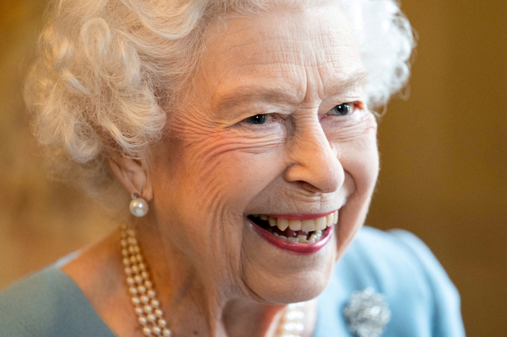 Britain's Queen Elizabeth reacts as she attends a reception in the Ballroom of Sandringham House which is the Queen's Norfolk residence, with representatives from local community groups to celebrate the start of the Platinum Jubilee, in Sandringham, Britain, February 5, 2022. Joe Giddens/ Pool via REUTERS/File Photo