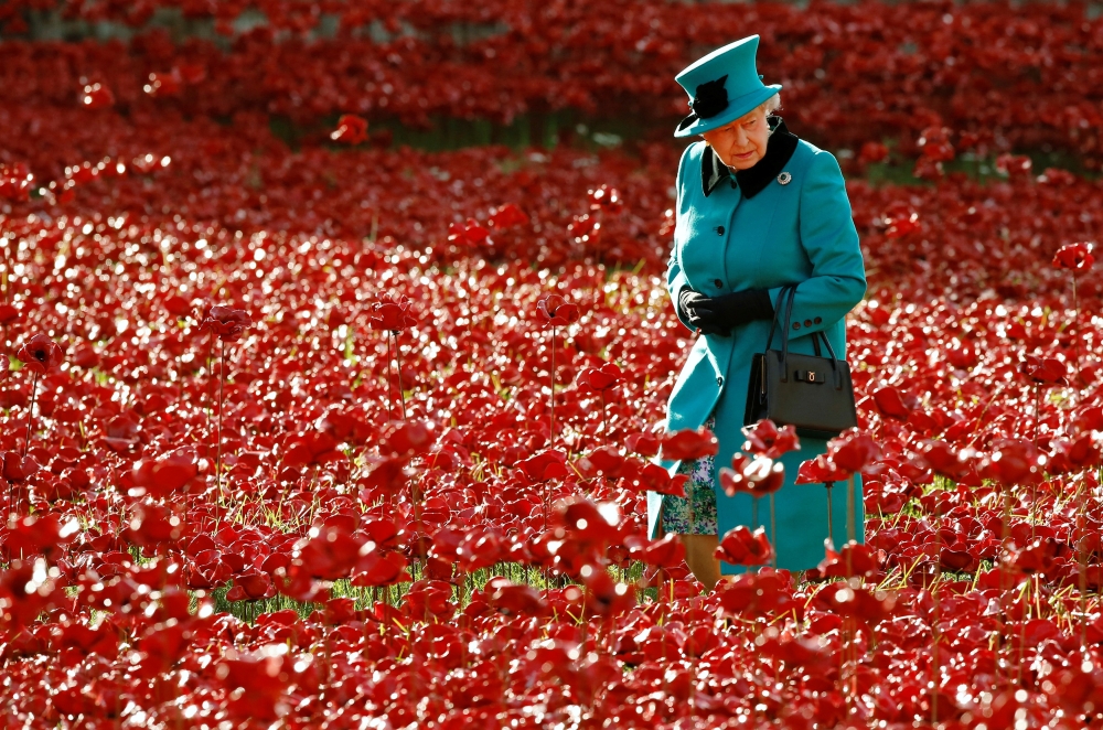 Britain's Queen Elizabeth II walks through a field of ceramic poppies at the Tower of London in London, Britain, on October 16, 2014. (REUTERS/Luke MacGregor)