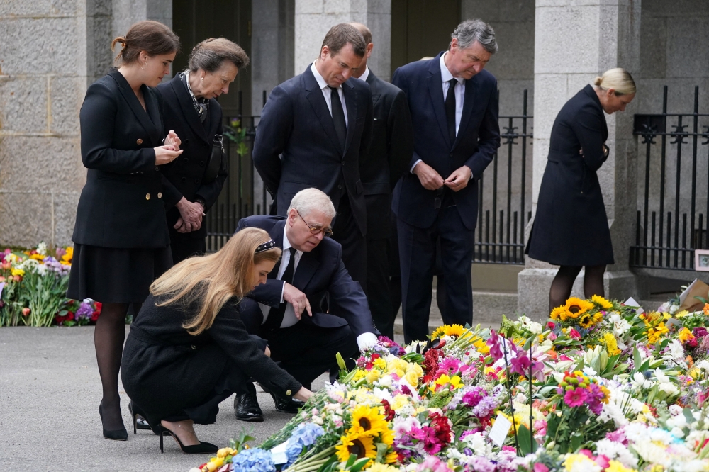 Britain's Princess Eugenie, Peter Phillips, Vice Admiral Sir Timothy Laurence, Zara Tindall, Princess Beatrice and Prince Andrew, Duke of York view the messages and floral tributes left by members of the public, following the passing of Britain's Queen Elizabeth, in Balmoral, Scotland, on September 10, 2022.
