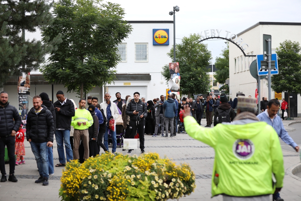 People queue to vote at a polling station for early voting in the suburb of Rinkeby, Stockholm, on September 10, 2022. TT News Agency/Ali Lorestani via REUTERS