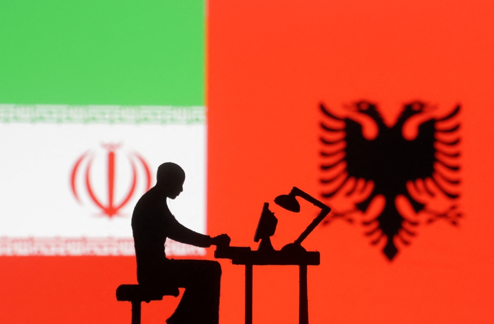 Figurines with computers are seen in front of Albanian and Iran flags in this illustration taken on September 10, 2022. REUTERS/Dado Ruvic/Illustration