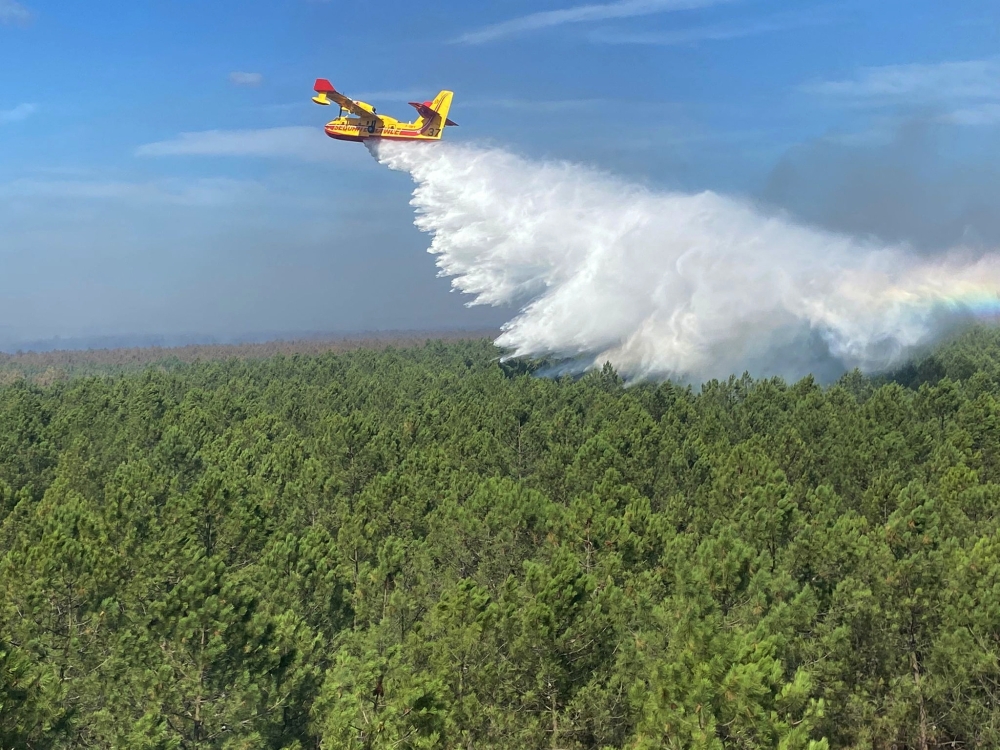 An aerial view shows a Canadair aircraft dropping water over the forest near Saumos in the Gironde region of southwestern France, in this handout picture released on September 14, 2022. SDIS 33/Handout via REUTERS