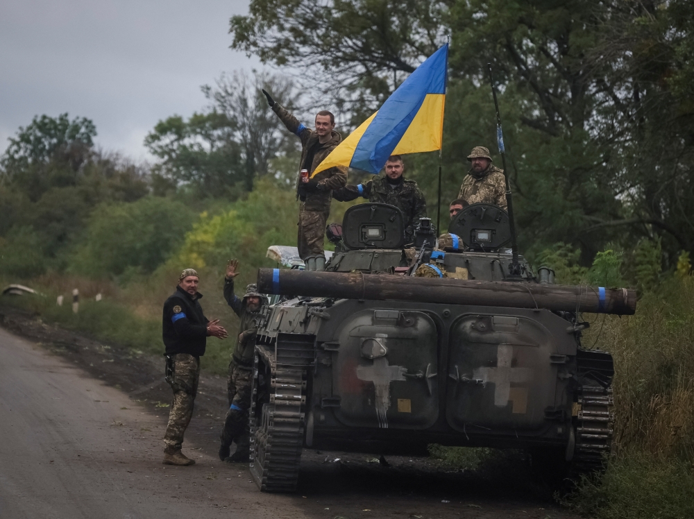 Ukrainian service members stand on a BMP-1 infantry fighting vehicle, amid Russia's attack on Ukraine, near the town of Izium, recently liberated by Ukrainian Armed Forces, in Kharkiv region  on September 14, 2022. REUTERS/Gleb Garanich