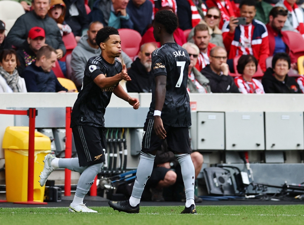 Arsenal's Ethan Nwaneri (left) shakes hands with Bukayo Saka as he comes on as a substitute during their EPL match against Brentford at the Brentford Community Stadium in London on September 18, 2022.   REUTERS/David Klein