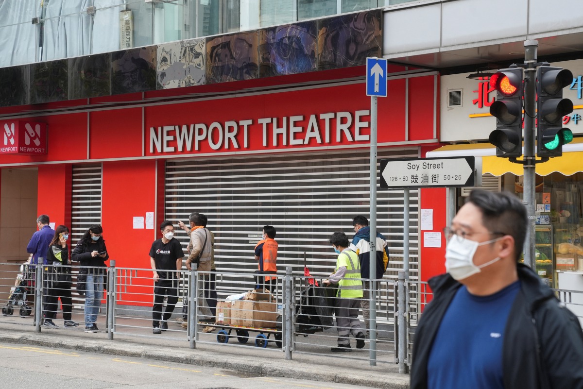 People wearing face masks, following the coronavirus disease outbreak, walk past a closed cinema in Hong Kong on February 16, 2022. File Photo / Reuters
