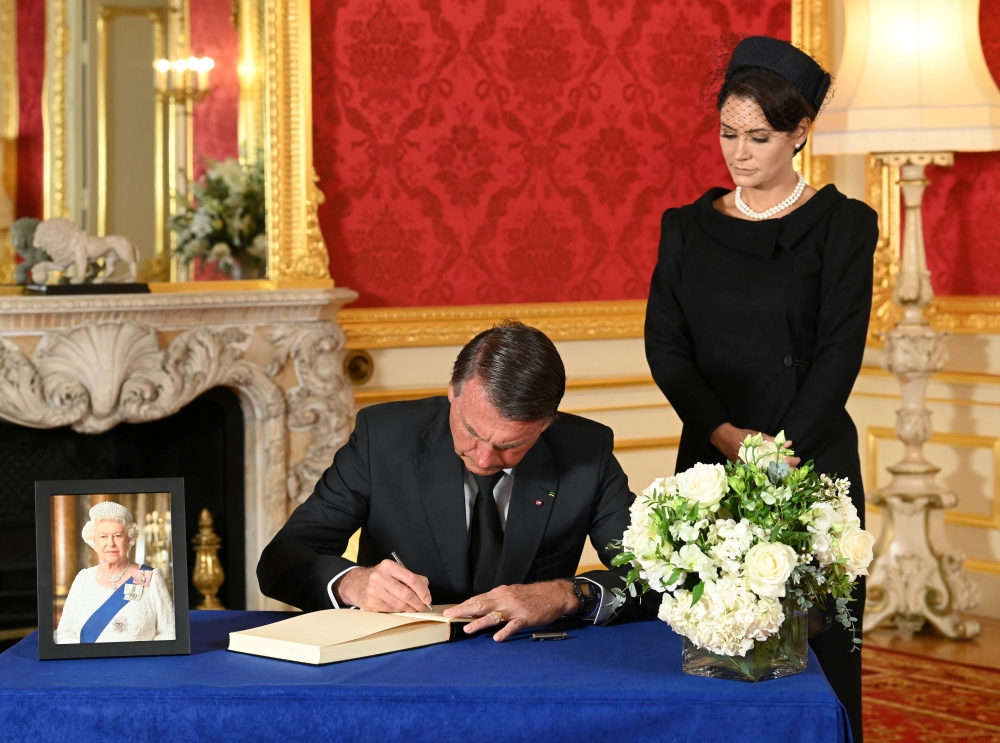 Brazilian President Jair Bolsonaro and First Lady Michelle de Paula Bolsonaro sign a book of condolence at Lancaster House in London, following the death of Queen Elizabeth II, on September 18, 2022. Jonathan Hordle/Pool via REUTERS