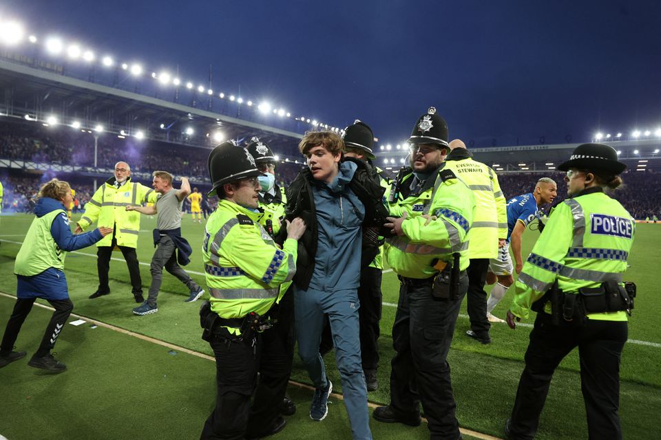 Police officer detain Everton fans as they celebrate avoiding relegation from the Premier League during a pitch invasion after the match against Crystal Palace at the Goodison Park in Liverpool on May 19, 2022.  File Photo / Reuters