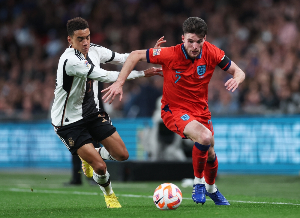 Germany's Jamal Musiala (left) in action against England's Declan Rice during their UEFA Nations League Group C match at the Wembley Stadium in London on September 26, 2022.  Action Images via Reuters/Carl Recine