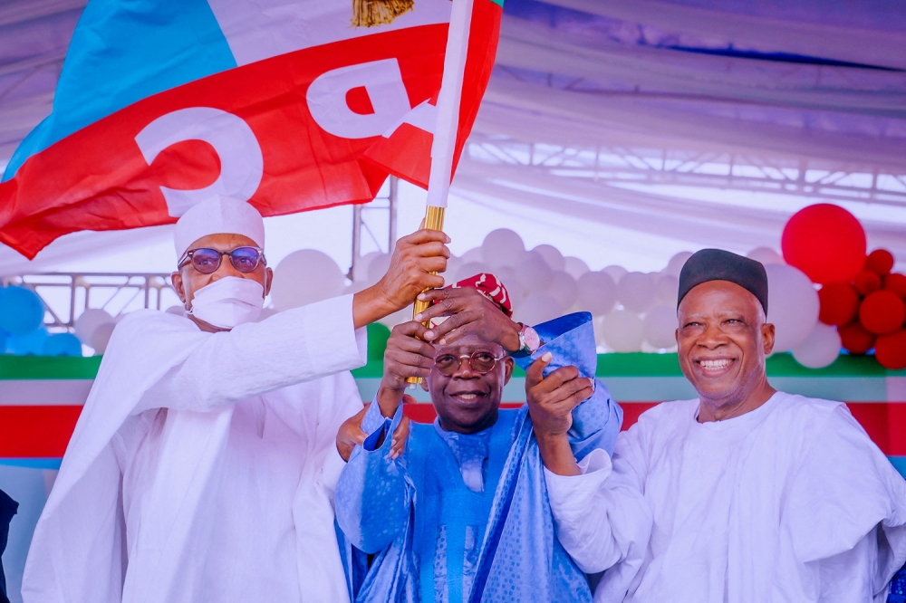 APC party's new presidential candidate Bola Tinubu raises a party's flag with Nigeria's President Muhammadu Buhari next to Abdullahi Adamu, the APC party chairman, during the party convention in Abuja, Nigeria, on June 7, 2022. (Nigeria's Presidency/Handout via REUTERS)