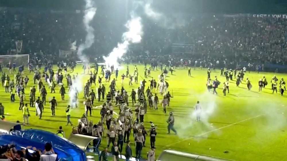 Fans invade the soccer field after a match between Arema FC and Persebaya Surabaya at Kanjuruhan Stadium, Malang, Indonesia Oct 2, 2022 in this screen grab taken from a REUTERS video. Reuters TV via Reuters