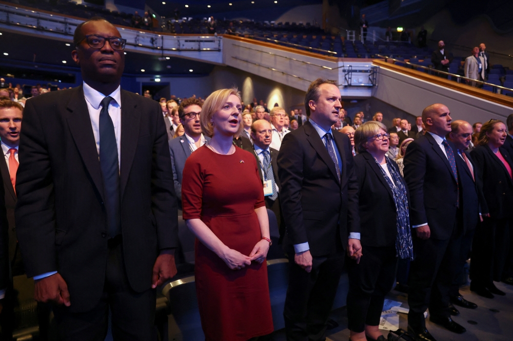 British Prime Minister Liz Truss, her husband Hugh O'Leary, Health Secretary Therese Coffey and Chancellor of the Exchequer Kwasi Kwarteng sing the national anthem, as they attend the annual Conservative Party conference, in Birmingham, Britain, on October 2, 2022. (REUTERS/Hannah McKay)