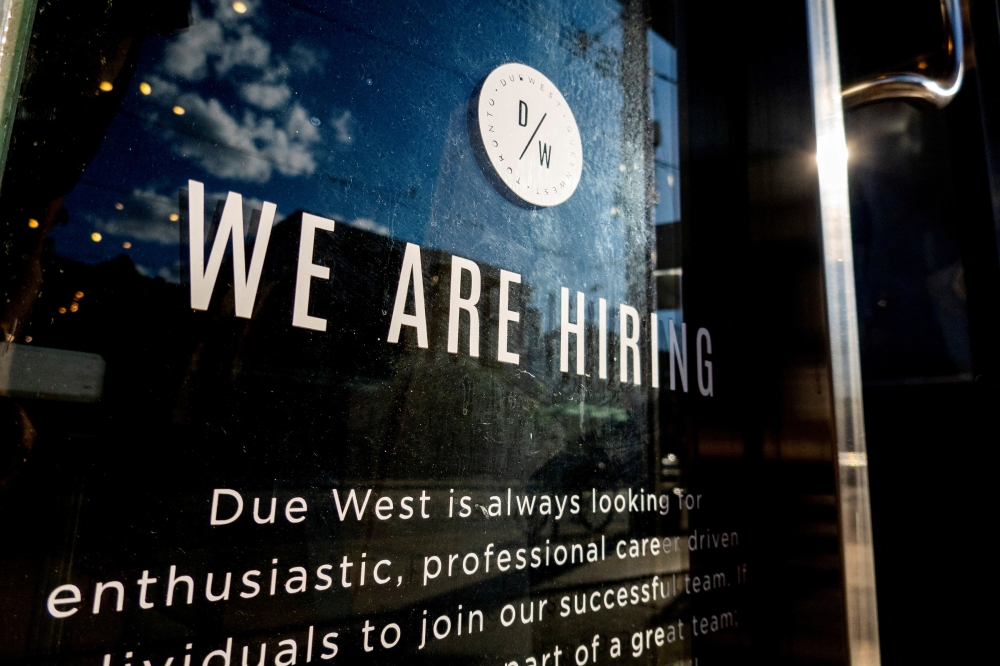 A help wanted sign at a store along Queen Street West in Toronto Ontario, Canada, June 10, 2022. (REUTERS/Carlos Osorio)