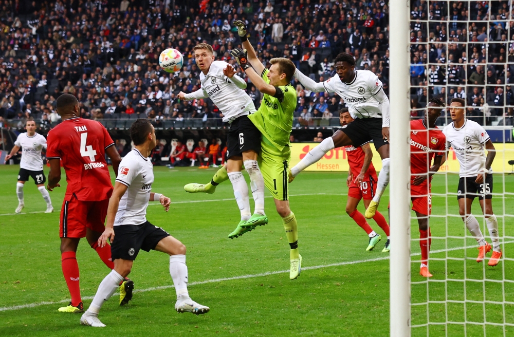 Eintracht Frankfurt v Bayer Leverkusen -  Eintracht Frankfurt's Kristijan Jakic in action with Bayer Leverkusen's Lukas Hradecky during their German Bundesliga match at the Deutsche Bank Park in Frankfurt  on October 15, 2022.  REUTERS/Kai Pfaffenbach 