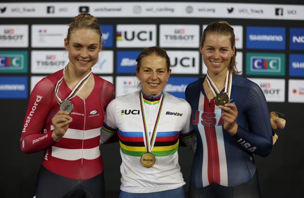 Gold medallist Britain's Neah Evans celebrates on the podium after winning the Women's Points Race of the US Tissot UCI Track World Championships 2022 alongside silver medallist Denmark's Julie Leth and bronze medallist Jennifer Valente at the National Velodrome, Saint-Quentin-En-Yvelines, France, on October 16, 2022.  REUTERS/Matthew Childs