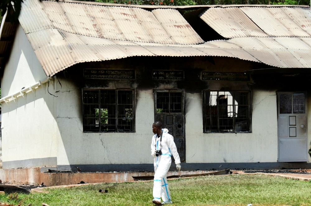 A forensic expert walks past a burnt dormitory building at the Salaama School for the Blind in Luga Village, Ntanzi Parish of Mukono District, near Kampala, Uganda October 25, 2022. REUTERS/Abubaker Lubowa