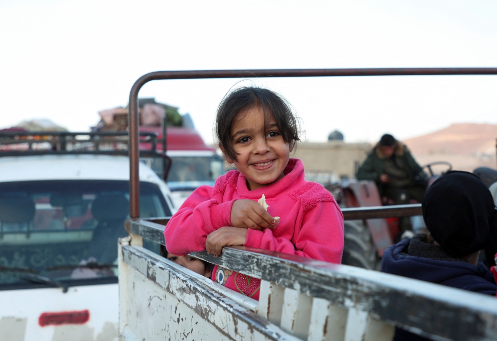 A girl stands on a pick-up truck as Syrian refugees prepare to return to Syria from Wadi Hmayyed, on the outskirts of the Lebanese border town of Arsal, Lebanon October 26, 2022. Reuters/Mohamed Azakir