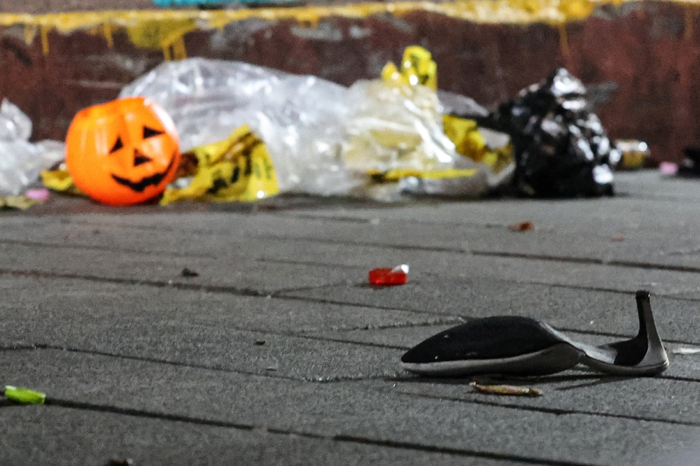 A shoe and a plastic halloween pumpkin are pictured at the scene where a stampede during Halloween festivities killed and injured many people at the popular Itaewon district in Seoul, South Korea, October 30, 2022. Yonhap via REUTERS