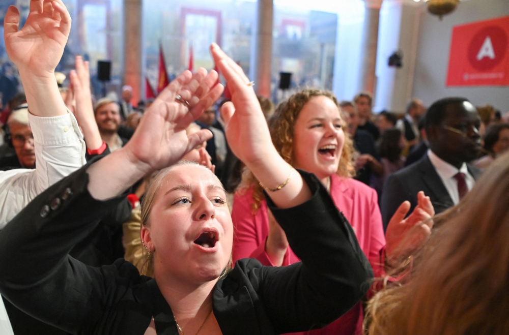 Supporters of the Social Democratic Party react to exit polls during the post-election partyin Copenhagen, Denmark, on November 2, 2022. - Denmark's Social Democrat Prime Minister Mette Frederiksen clung to power in the November 1 general election after the country's left-wing bloc won a one-seat majority, final results showed. (Photo by Jonathan NACKSTRAND / AFP)