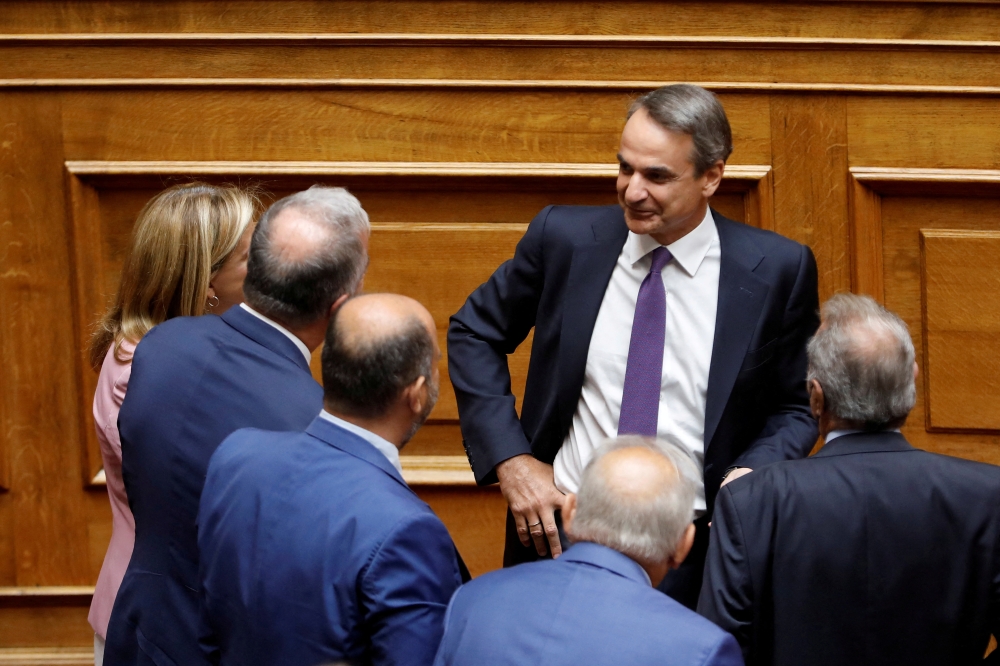 File Photo: Greek Prime Minister Kyriakos Mitsotakis speaks with members of his government and lawmakers during a parliamentary session on a wiretapping case, in Athens, Greece, August 26, 2022. (REUTERS/Costas Baltas)