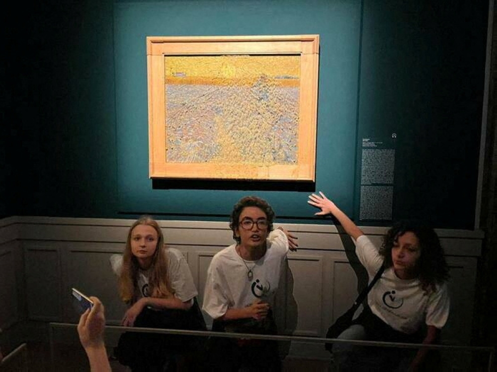 Activists of 'Ultima Generazione (Last Generation)' glue their hands to the wall after throwing soup at a van Gogh's painting 'The Sower' at Palazzo Bonaparte in Rome, Italy, November 4, 2022. (Arthemisia/Handout via REUTERS)