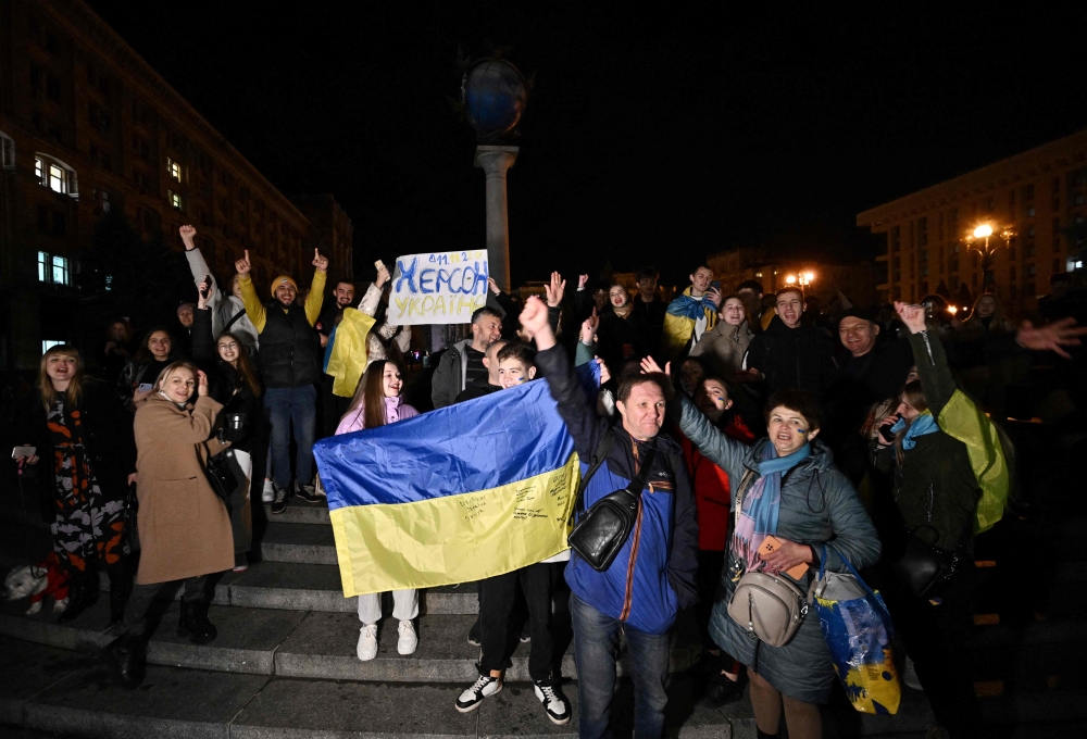 People hold a Ukrainian flag and a slogan which reads 