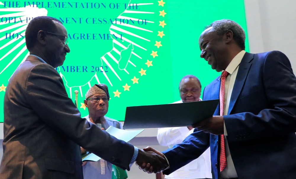 Field Marshal of the Ethiopian National Defence Force and Chief of General Staff of Ethiopia Birhanu Jula and Tadesse Werede Tesfay, the Commander-in-Chief of the Tigray forces, exchange documents after the signing of the implementation of the cessation of hostilities agreement between the Ethiopian government and Tigrayan forces, laying out the roadmap for implementation of a peace deal, in Nairobi, Kenya, on November 12, 2022. REUTERS/Thomas Mukoya