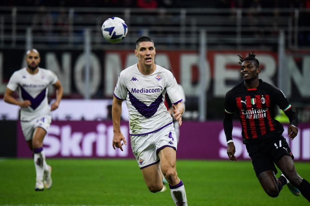 Fiorentina's Serbian defender Nikola Milenkovic and AC Milan's Portuguese forward Rafael Leao (R) go for the ball during the Italian Serie A football match between AC Milan and Fiorentina on November 13, 2022 at the San Siro stadium in Milan. (Photo by Filippo MONTEFORTE / AFP)
