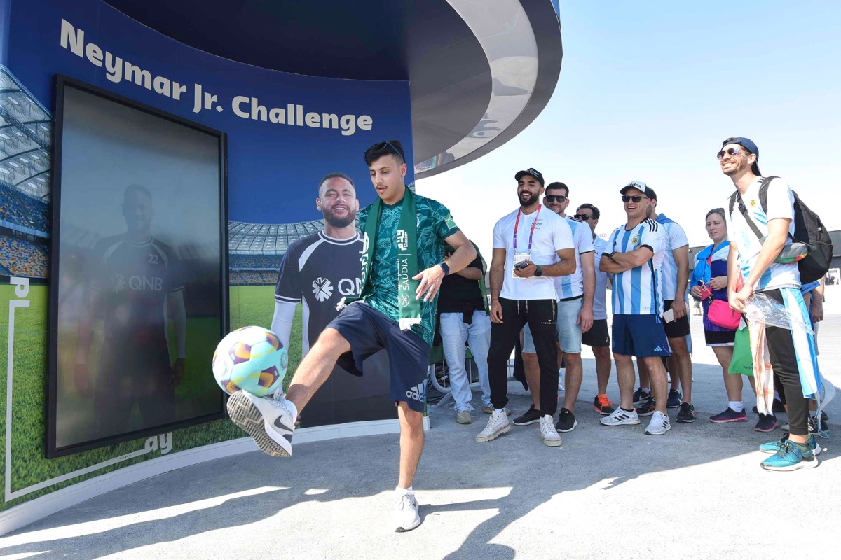 Fans participating in football activities at Lusail stadium.