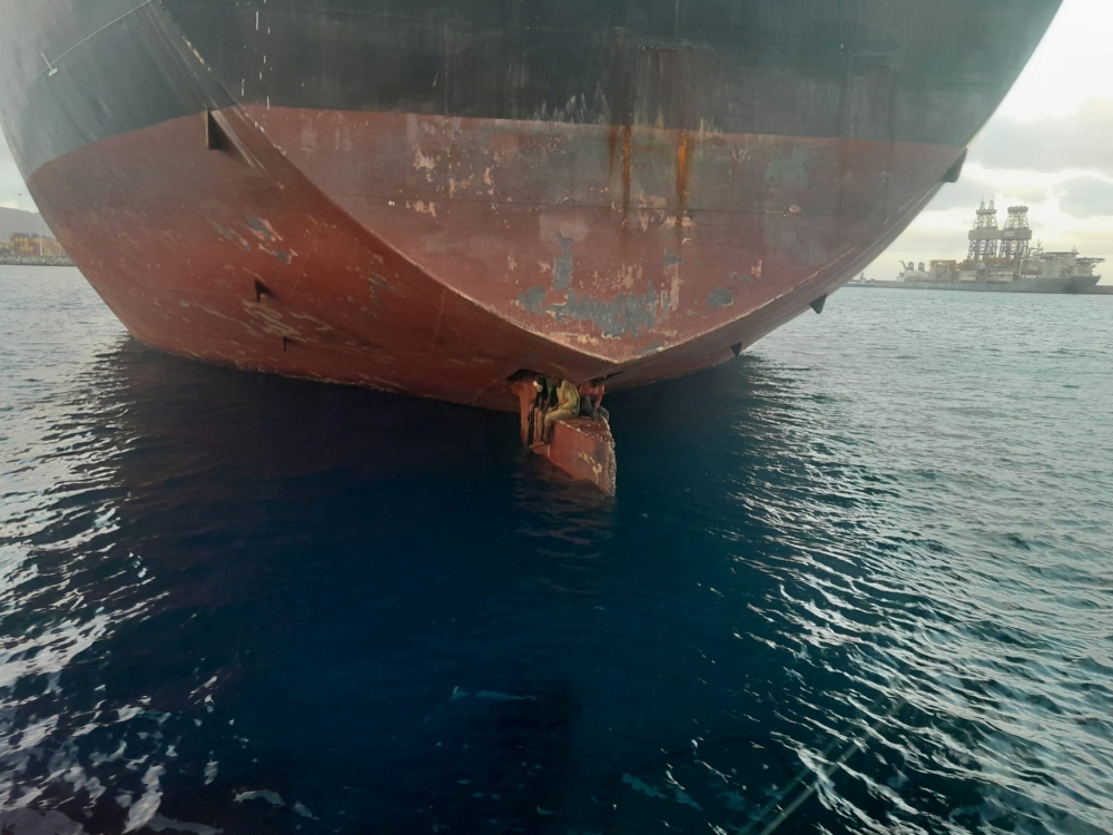 Three stowaway migrants are seen on the rudder blade of petrol vessel Althini II after traveling from Nigeria and before being rescued by Spanish coast guard, in this picture released on the Salvamento Maritimo official Twitter account. Salvamento Maritimo/Handout via Reuters 