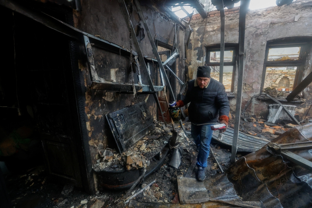 Local resident Pavel gathers belongings of his neighbour, who was killed in recent shelling, in his neighbour's house destroyed in the course of Russia-Ukraine conflict in Donetsk, Russian-controlled Ukraine, December 10, 2022. REUTERS/Alexander Ermochenko