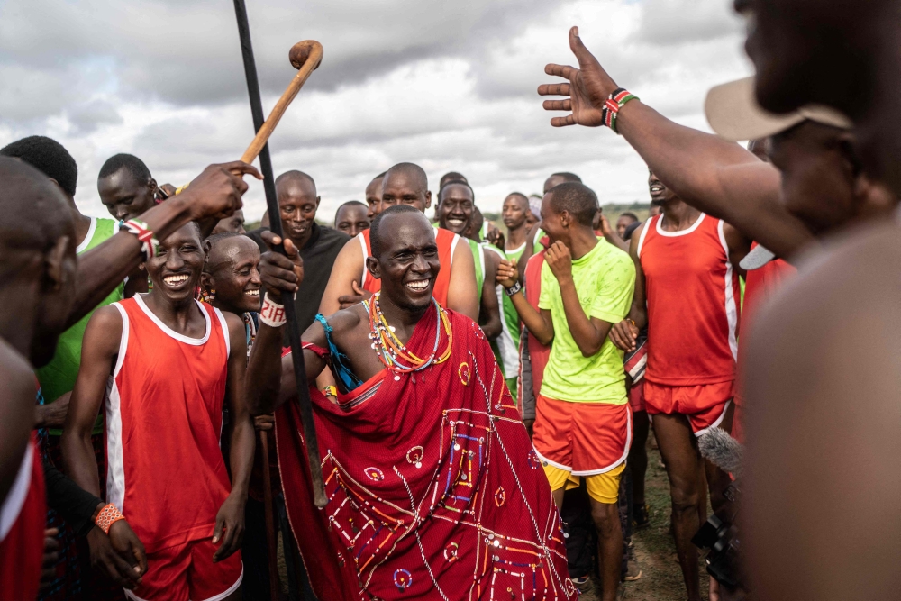 A group of participants and supporters dance during the Maasai Olympics in Kimana district, on December 10, 2022, a sports event first held in 2012, in the Amboseli-Tsavo ecosystem. (Photo by Fredrik Lerneryd / AFP)