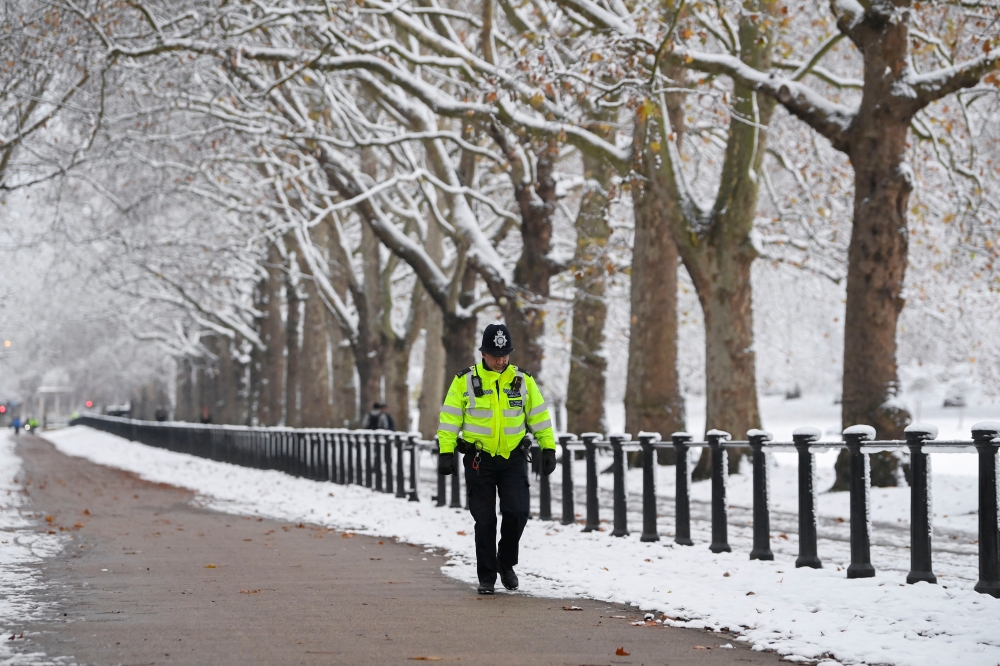 A police officer walks on the street as cold weather continues, in London, Britain, December 12, 2022. REUTERS/Toby Melville
