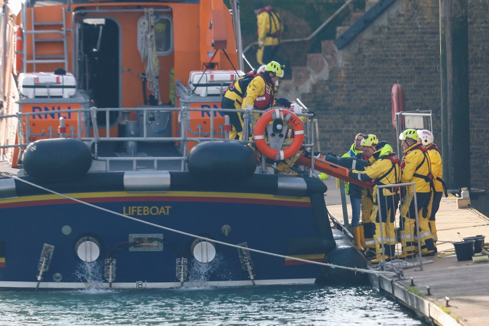 Rescue workers carry a body bag on a stretcher, as they return to the Port of Dover amid a rescue operation of a missing migrant boat, in Dover, Britain December 14, 2022. Reuters/Peter Nicholls