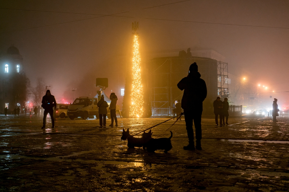 People walk past a Christmas tree during heavy fog at the Sofiyska square, amid Russia's invasion of Ukraine, in Kiev, Ukraine December 17, 2022. REUTERS/Vladyslav Musiienko TPX IMAGES OF THE DAY