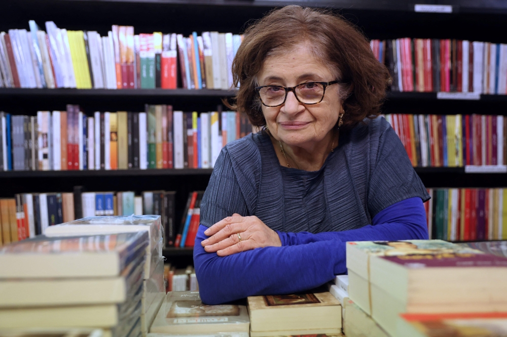 Bookshop director Salwa Gaspard poses for pictures at Middle Eastern specialist bookshop, Al Saqi Books, in Bayswater, west London, on December 14, 2022. (Photo by Isabel Infantes / AFP)