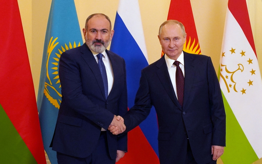 Russian President Vladimir Putin (R) greets Armenian Prime Minister Nikol Pashinyan ahead of an informal meeting of the heads of state of the Commonwealth of Independent States (CIS) at the Boris Yeltsin Presidential Library in Saint Petersburg on December 26, 2022. (Photo by Alexey DANICHEV / SPUTNIK / AFP)