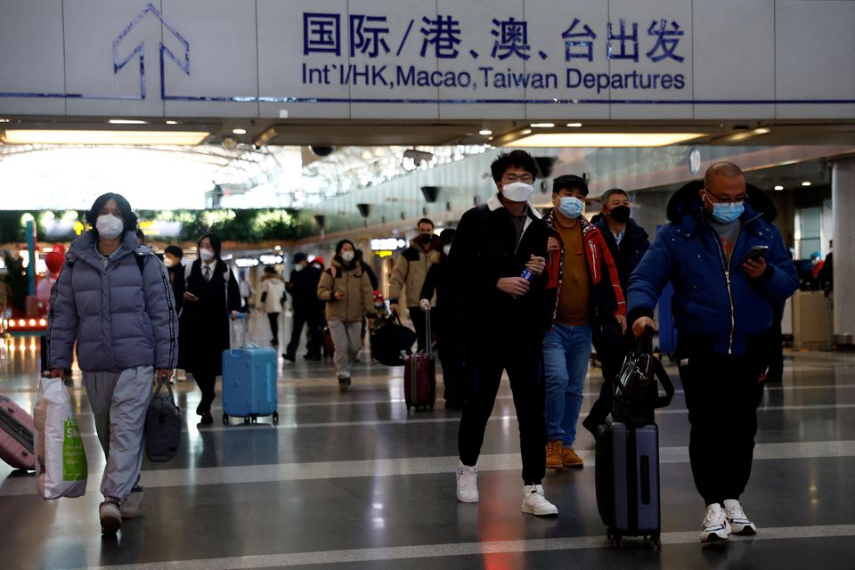 Travellers walk with their luggage at Beijing Capital International Airport, amid the coronavirus disease (COVID-19) outbreak in Beijing, China December 27, 2022. REUTERS/Tingshu Wang/File Photo