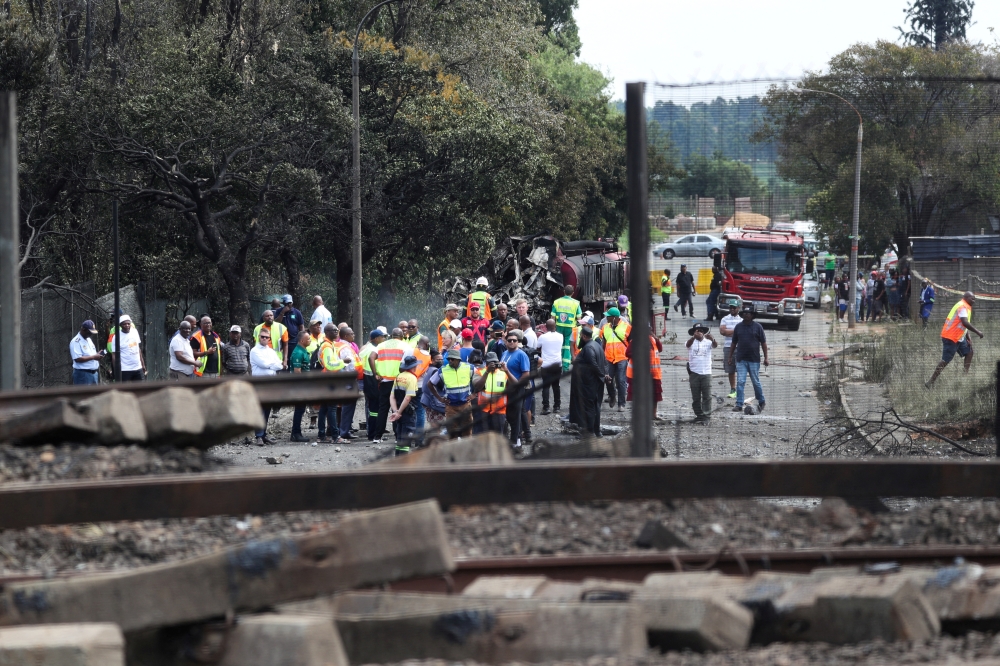 People gather near a burnt out truck at the entrance of the damaged bridge where a gas tanker exploded in Boksburg near Johannesburg, South Africa, December 24, 2022. REUTERS/Sumaya Hisham/File Photo