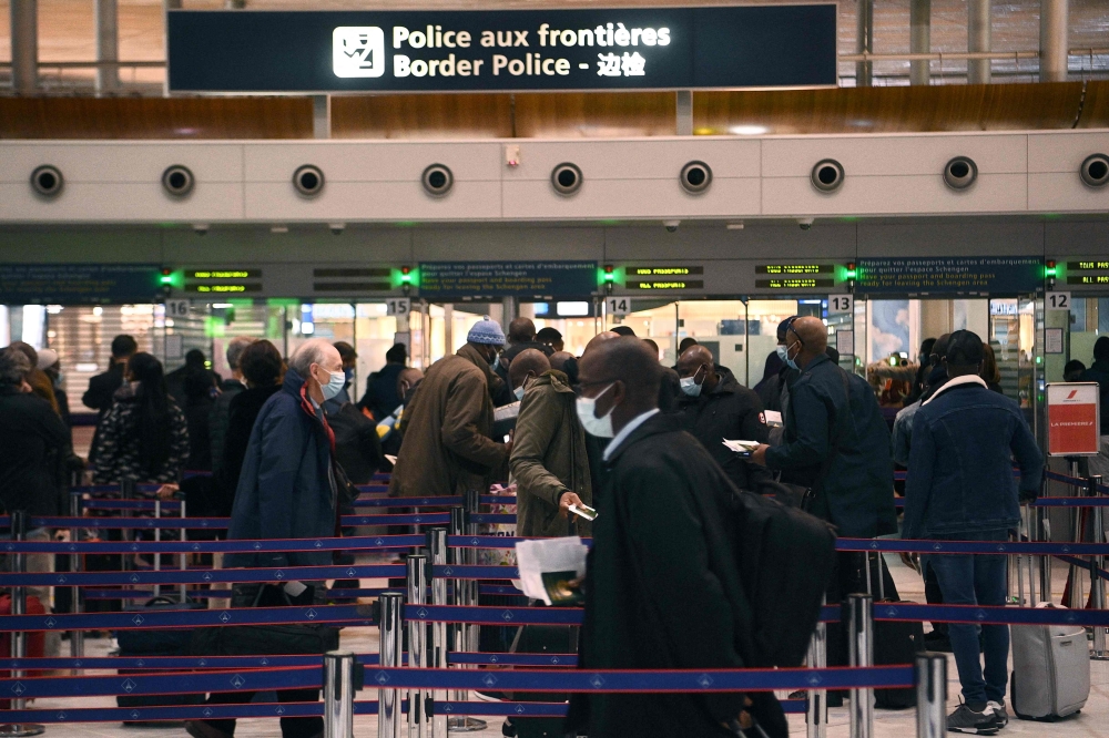 In this file photo taken on February 1, 2021, travellers queue at the immigration desk of Roissy Charles-de-Gaulle international airport, as new Covid-19 border restrictions come into effect.  (Photo by Christophe ARCHAMBAULT / AFP)