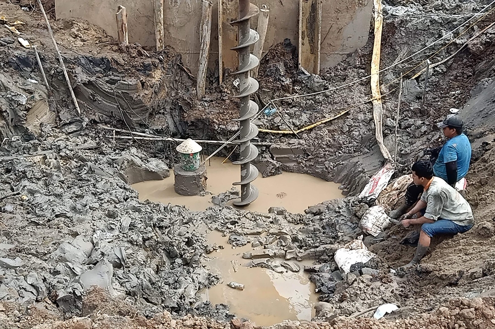 Rescuers gather at the site of where a 10-year-old boy is thought to be trapped in a 35-metre deep shaft at a bridge construction area in Vietnam's Dong Thap province on January 2, 2023.  Photo by AFP